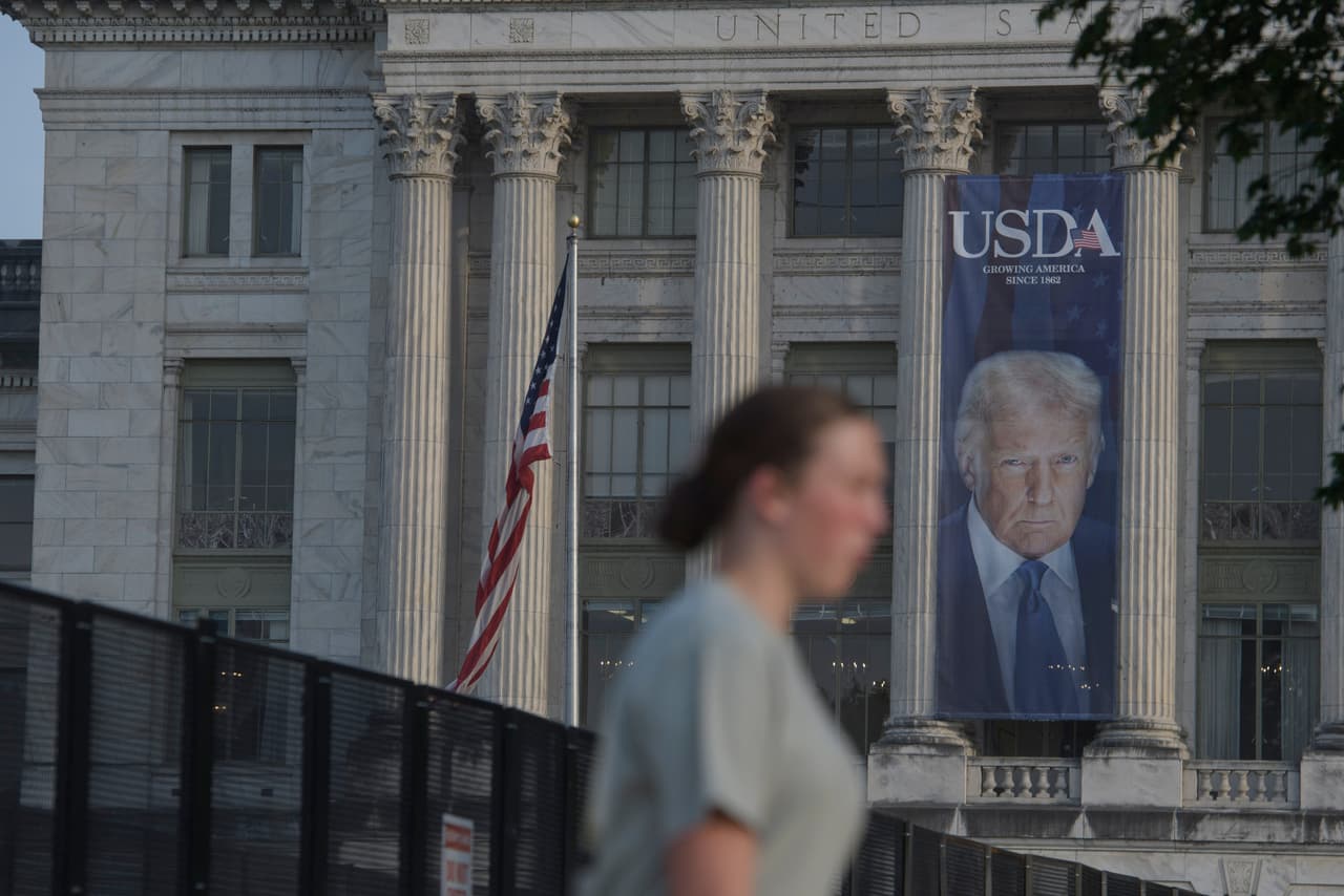 Una mujer pasa junto a la valla de seguridad instalada en el National Mall, durante los preparativos para un próximo desfile militar que conmemora el 250.º aniversario del Ejército y coincide con el 79.º cumpleaños del presidente Donald Trump, el jueves 12 de junio de 2025 en Washington.