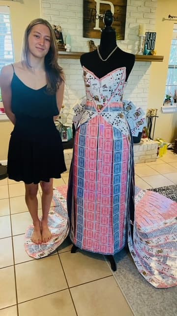 Kaylee comenzó el diseño de este vestido por diversión, inspirada en un disfraz de Reina de Corazones. 
<b>Tras 60 horas de trabajo, el resultado sorprendió a su familia</b>, tanto que su madre le aconsejó participar en el concurso Diseñador Artesano (Designer's Craftsman) de la Feria Estatal de Texas.