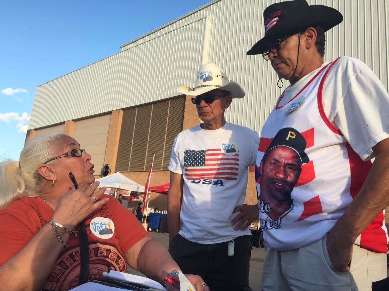 Al final del recorrido, Sylvia Marcano informa a dos puertorriqueños del trabajo de Boricua Vota.