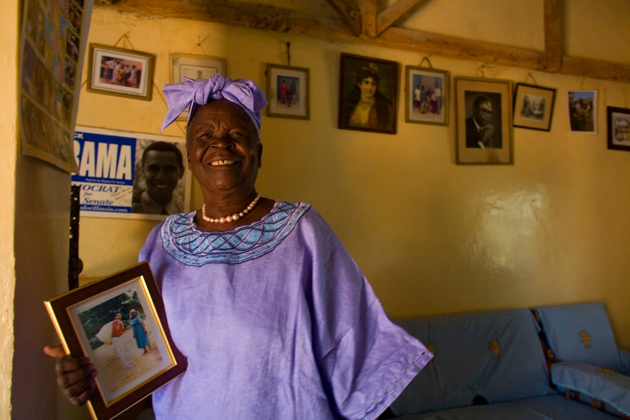 La abuela del expresidente en su casa en 2008, con una de las fotografías junto a su nieto en las manos. La Fundación 'Mamá Sarah' Obama proporcionó alimentos y educación a los niños que perdieron a sus padres.. Entregaba útiles escolares, uniformes, ayudaba con las necesidades médicas básicas y pagaba cuotas escolares.