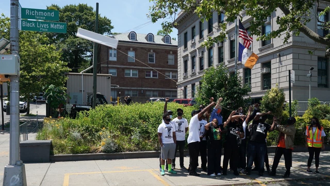 El alcalde de Nueva York, Bill de Blasio (de azul con mascarilla roja) encabezó el acto con un grupo de voluntarios.