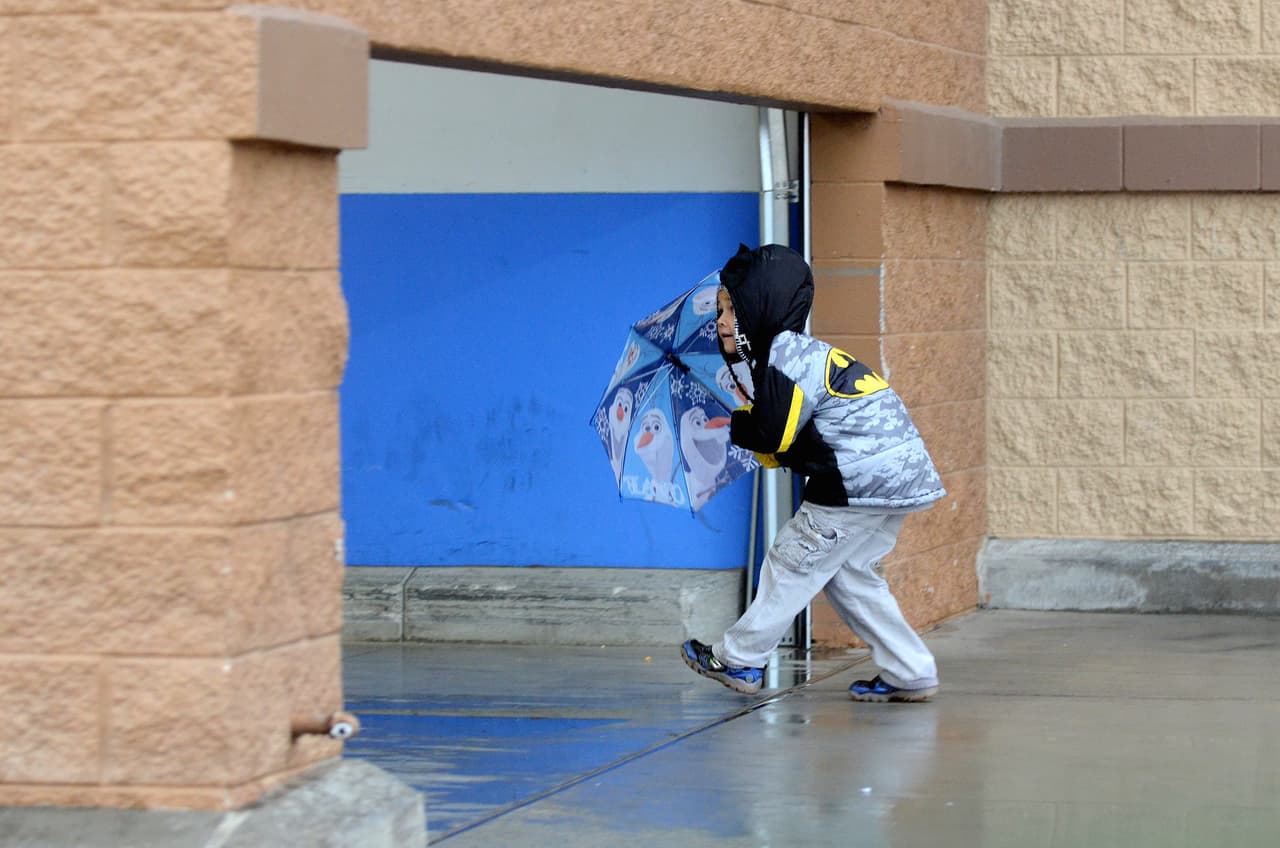 En Hespería, un niño entrando a una tienda bajo la lluvia