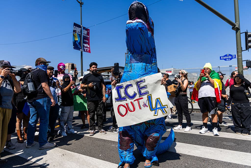 En estos días, al centro de Los Ángeles 
<b>ha llegado más de un dinosaurio inflable</b>, desde los violetas como Barney y otros rojos, todos con 
<b><a href="https://www.univision.com/local/los-angeles-kmex/tercer-dia-de-protestas-contra-ice-en-los-angeles-las-imagenes-de-un-caos-provocado-por-el-gobierno-de-trump-fotos" target="_blank">mensajes contra la presencia de ICE</a></b>. Este azul, presumía el martes una pancarta con una orden clara,
<b> sin recurrir al insulto: "ICE fuera de LA"</b>.