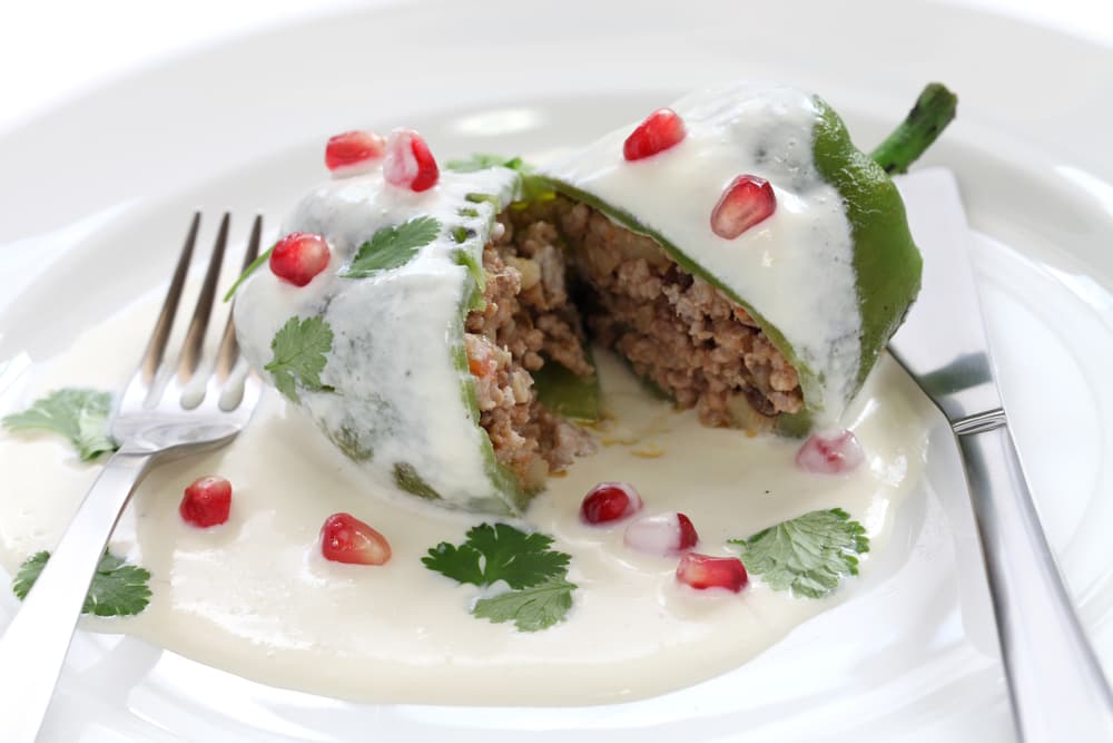 Cuando notes que ya está bien frita agrega el puré de jitomate, después incorpora las pasas, las almendras peladas y picadas, el acitrón; se agregan las frutas bien picadas primero el durazno, la manzana, la pera. Cuando ya estén cocidas agrega el plátano macho.