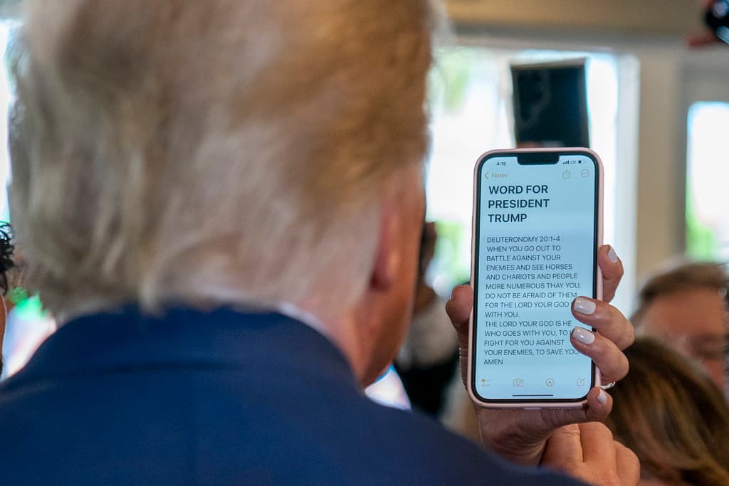Al expresidente una mujer le puso de frente su teléfono móvil que tenía en pantalla "Palabra para el presidente Trump" y luego una cita del libro bíblico del Deuteronomio
<i>. "Cuando salgas a la guerra contra tus enemigos, si vieres caballos y carros, y un pueblo más grande que tú, no tengas temor de ellos, porque Dios está contigo..."</i>
