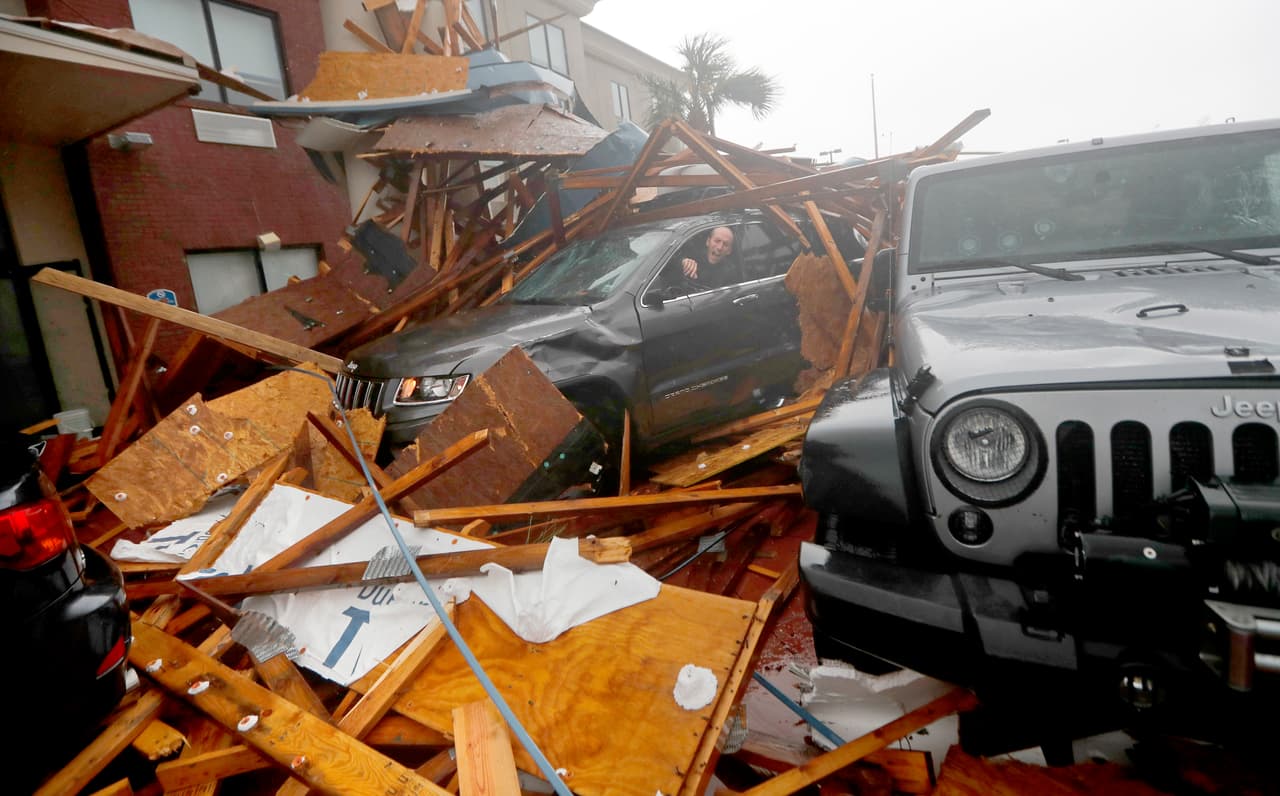 Un cazador de tormentas entra a su vehículo tapiado por los escombros de un techo que colapsó en un hotel de Panama City Beach, Florida. Michael tocó tierra aproximadamente a la 1:37 pm de este miércoles como un huracán categoría 4.