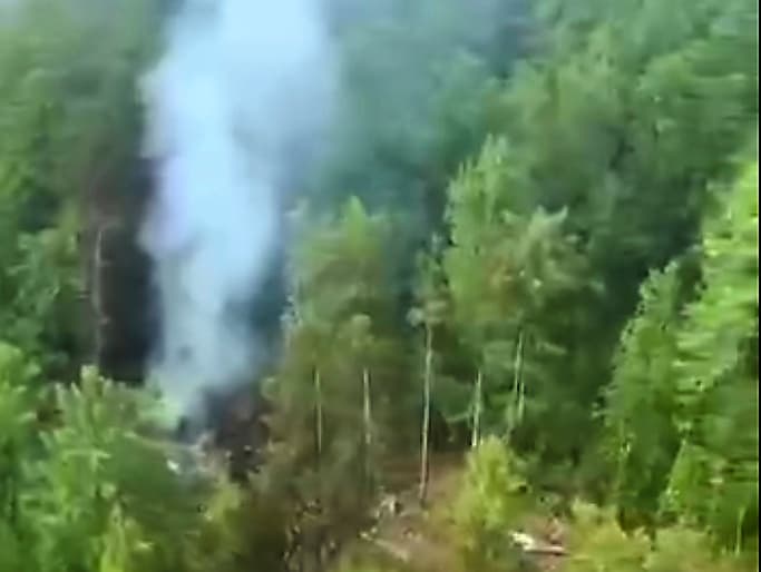 En esta foto, tomada de un video difundido por el servicio de prensa del Ministerio de Situaciones de Emergencia de Rusia este jueves 24 de julio de 2025, se puede ver humo saliendo del lugar del accidente del avión de pasajeros An-24.