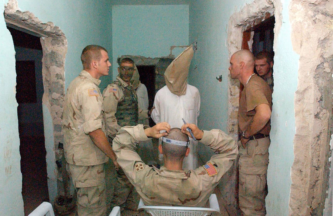 4 de julio de 2003, soldados estadounidenses interrogan en Balad a un prisionero acusado de ser un alto funcionario de la policía secreta y miembro del partido Baath, la agrupación política de Saddam Hussein. El gobernante iraquí era buscado por todo el país por las fuerza estadounidenses.