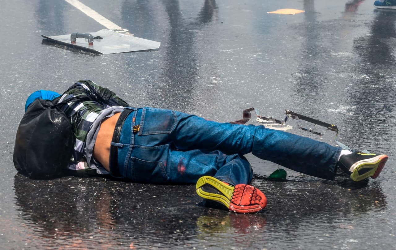 Un activista opositor herido en el suelo de la autopista.