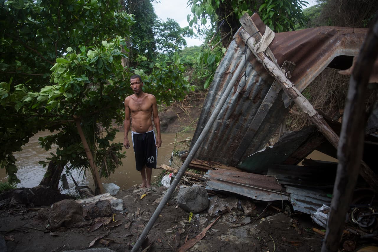 Un lugareño está de pie junto a su hogar destruido.