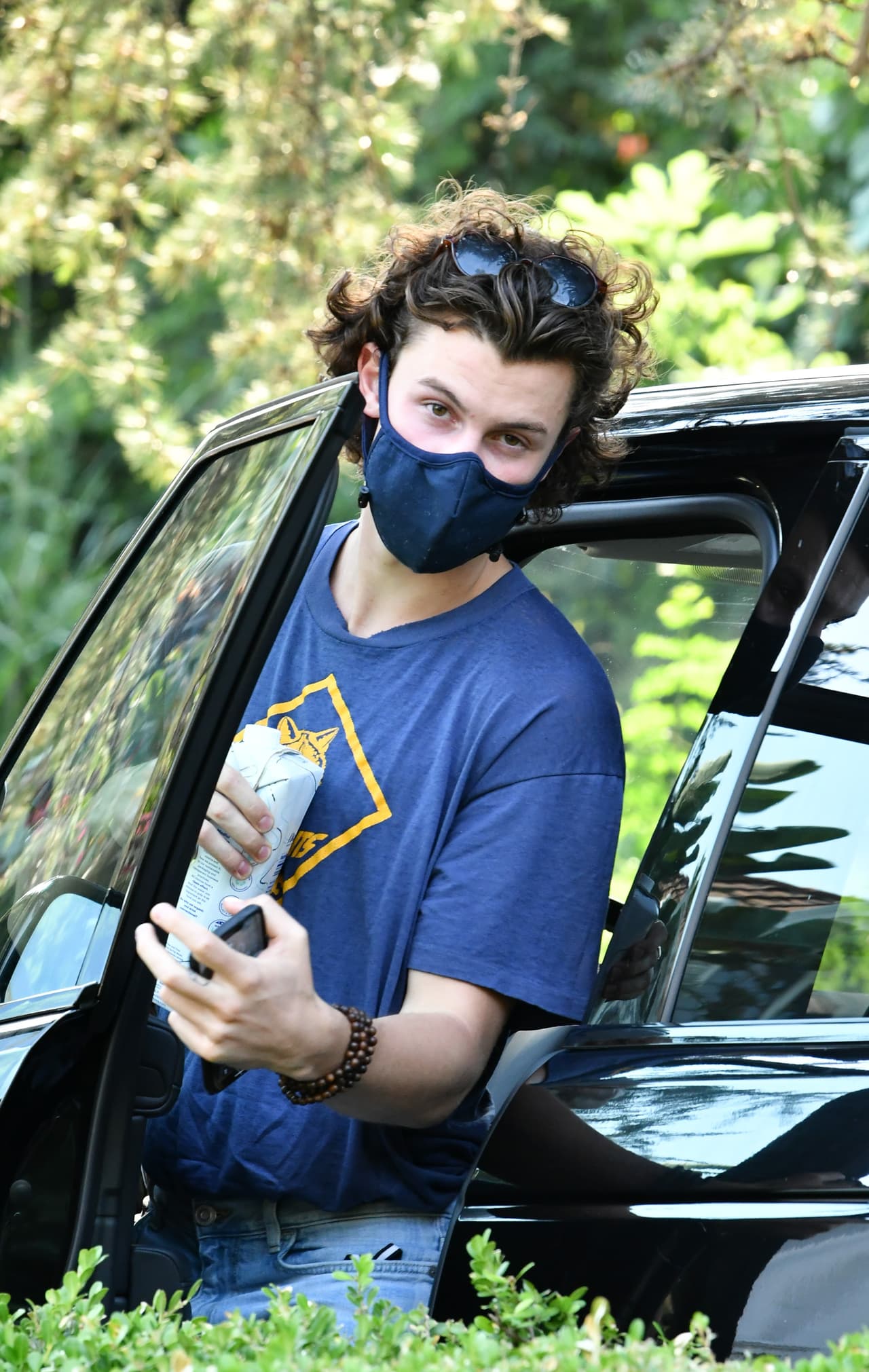 Al estudio de grabación angelino también llegó Shawn Mendes. Para su salida, el intérprete utilizó un cubrebocas azul, una playera del mismo color, con un emblema de un club scout impreso, jeans azules y lentes de sol.