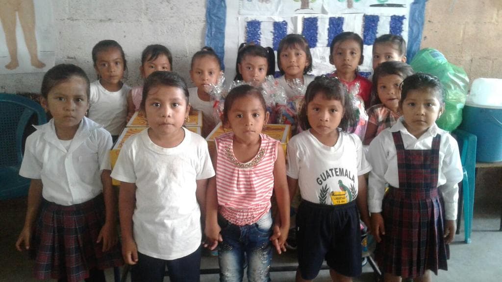 Yanci (the second from the left) along with her classmates in Guatemala before migrating with her father to the United States.
