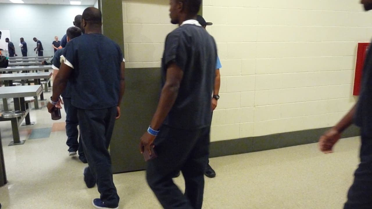 Los inmigrantes van en fila al comedor de la institución.