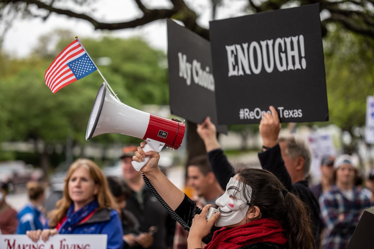Los manifestantes frente al Capitolio texano, con banderas estadounidenses y carteles que leen "suficiente". Las primeras manifestaciones en contra de las restricciones y las órdenes de 'quedarse en casa' cobraron fuerza previamente esta semana en Michigan, donde la gobernadora demócrata Gretchen Whitmer impuso fuertes restricciones. En Texas, el gobernador Greg Abbott permitió la 'reapertura' de parques y alentó a los negocios hacer lo mismo.