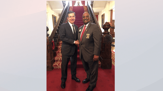 De izquierda a derecha, Gobernador de Carolina del Norte, Roy Cooper y Alguacil del Condado de Durham, Clarence F. Birkhead