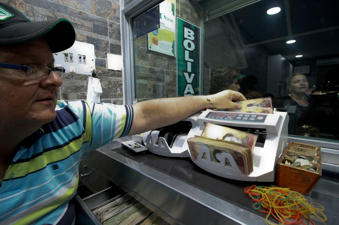 Un hombre cuenta dinero venezolano en una casa de cambio ubicada en la población colombiana de La Parada, fronteriza con Venezuela, el mismo día que el presidente Nicolás Maduro anunció el retiro de los billetes de cien bolívares como medida para combatir el supuesto tráfico de papel moneda hacia Colombia.