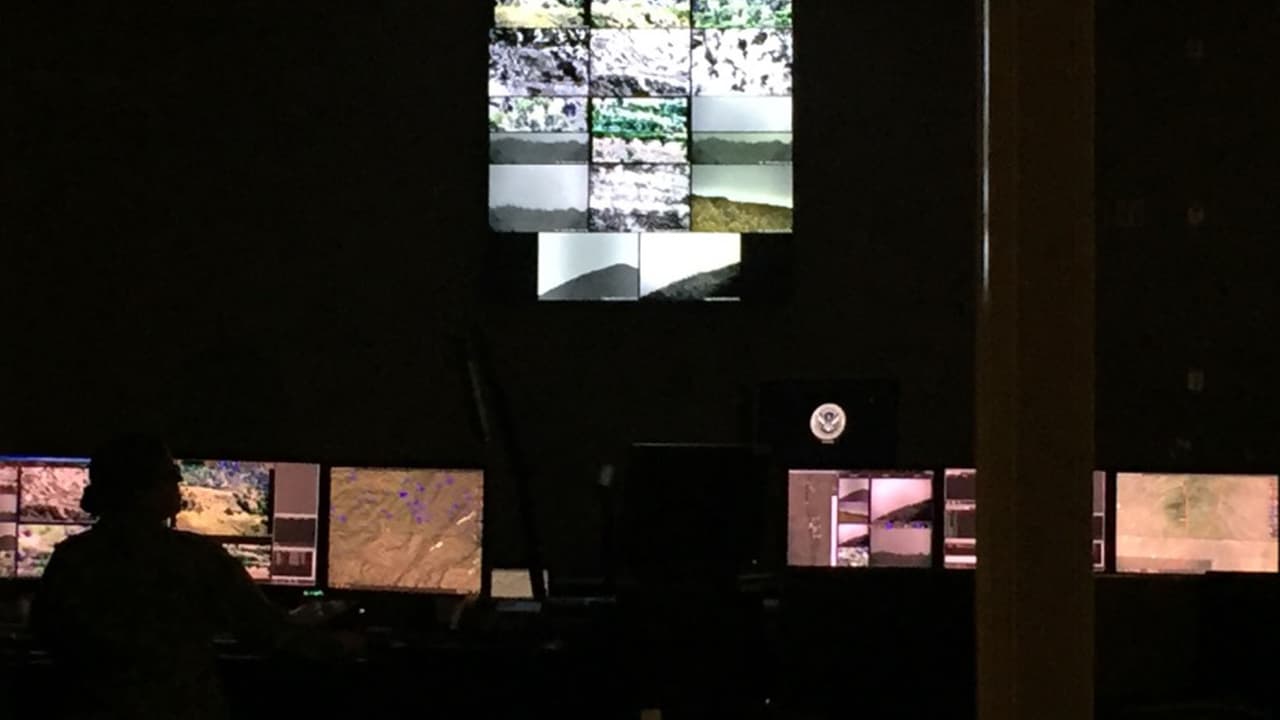 Seis miembros de la Guardia Nacional trabajan en el centro de operaciones controlando el sistema de vigilancia de las cámaras en la frontera.