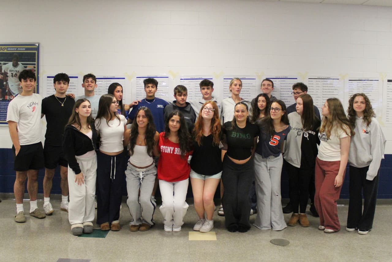 Estudiantes gemelas posan para una foto grupal durante el ensayo para la ceremonia de graduación de la Escuela Secundaria John F. Kennedy de Plainview-Old Bethpage en la Universidad de Hofstra en Hempstead, Nueva York.