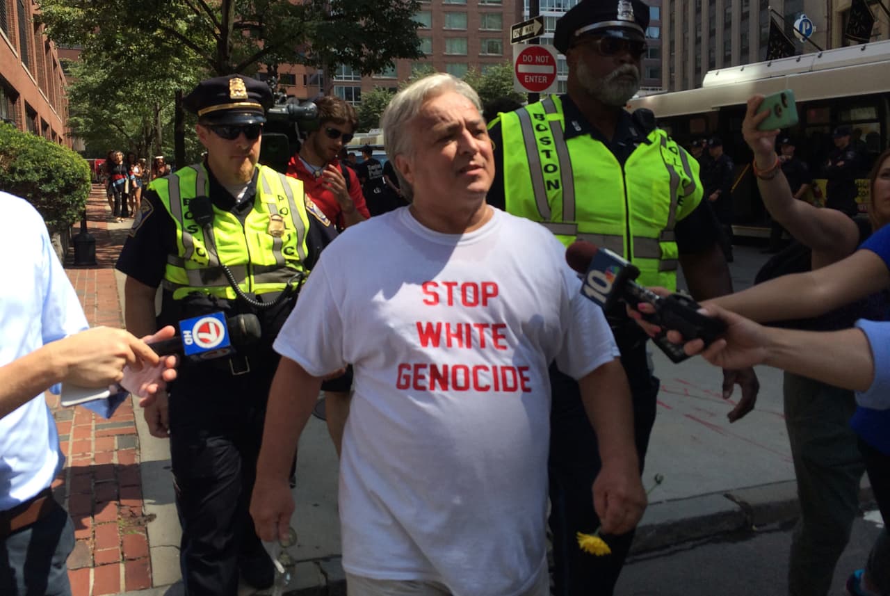 An attendee of the Boston Free Speech Rally is escorted out of Boston Common by members of the police.