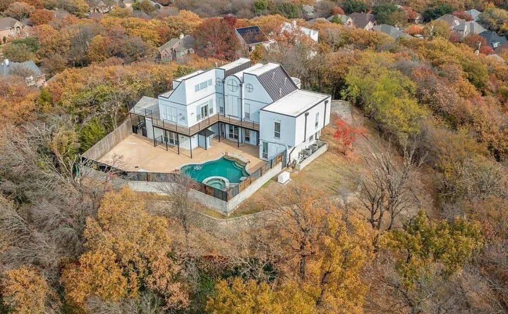 La residencia se ubica en la cuadra
<a href="https://www.google.com/maps/place/1209+Hickory+Valley+Ct,+Arlington,+TX+76006/@32.7776016,-97.0916397,17z/data=!3m1!4b1!4m5!3m4!1s0x864e875764d6c6d3:0xc45aaecf415c7281!8m2!3d32.7776016!4d-97.089451" target="_blank">1209 Hickory Valley Court ,</a> en lo alto de una colina, mide unos 3,784 pies cuadrados y tiene 1,5 acres de propiedad rodeada de árboles. Tiene vistas hacia Fort Worth y Las Colinas, Texas.