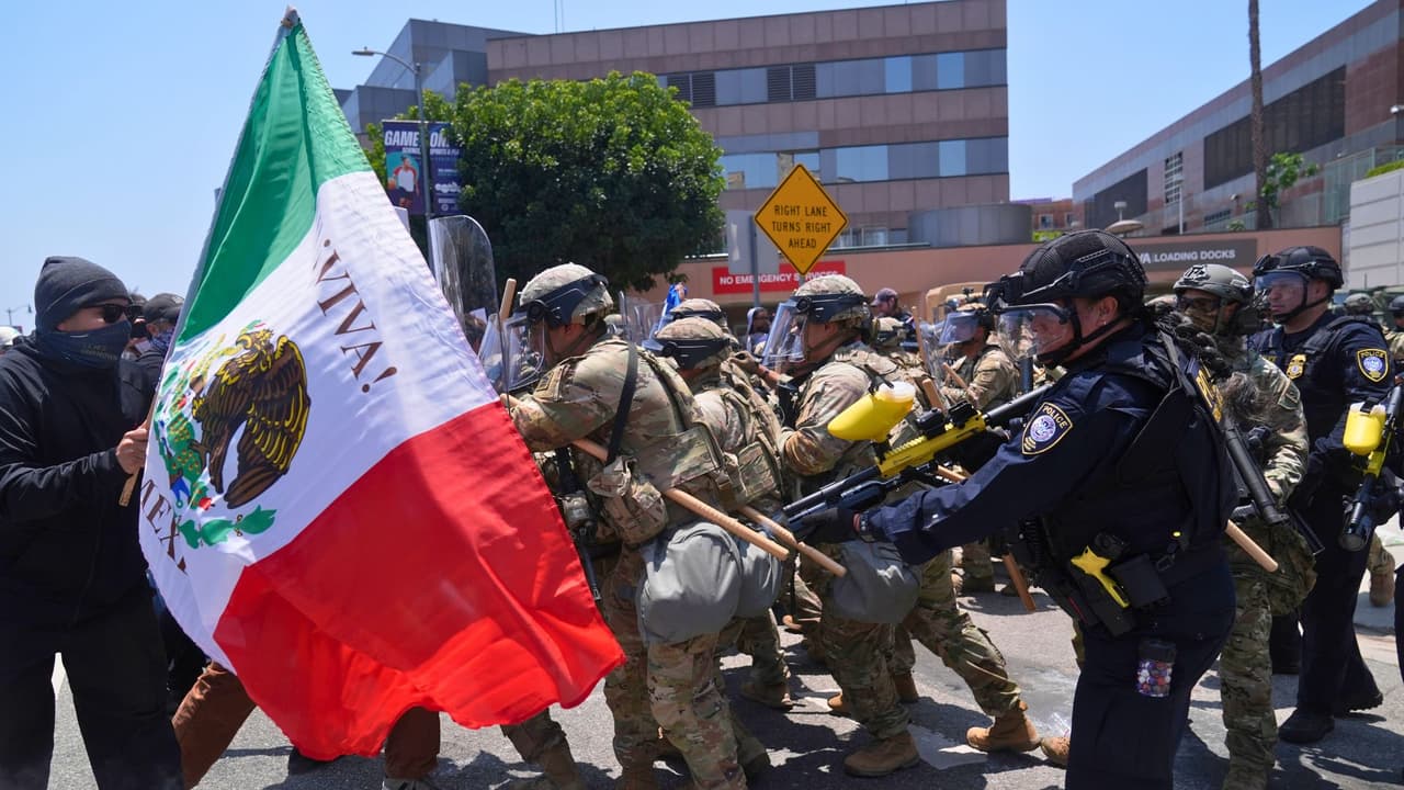 Manifestantes chocan con las autoridades en el centro de Los Ángeles, domingo 8 de junio de 2025, tras la protesta de anoche contra las redadas de inmigración.