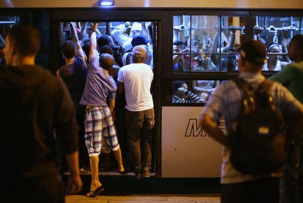 Un grupo de personas buscan subir a un abarrotado camión en la calle del National Capitol Building.