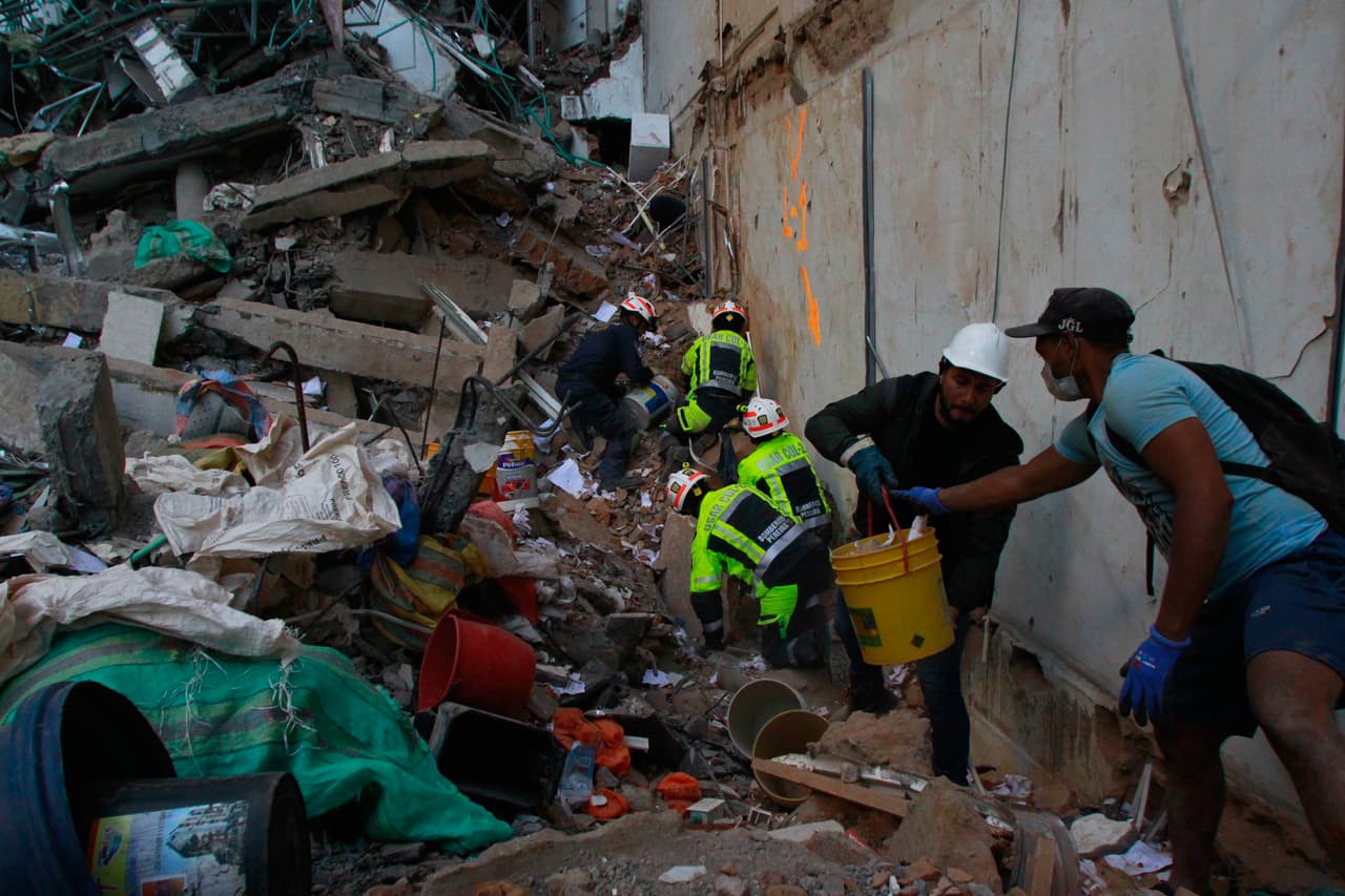 Los socorristas armaron cadenas humanas para sacar los escombros del edificio, con picos y herramientas básicas. Cada tanto gritan "silencio" para ver si escuchan señales de vida de los atrapados.