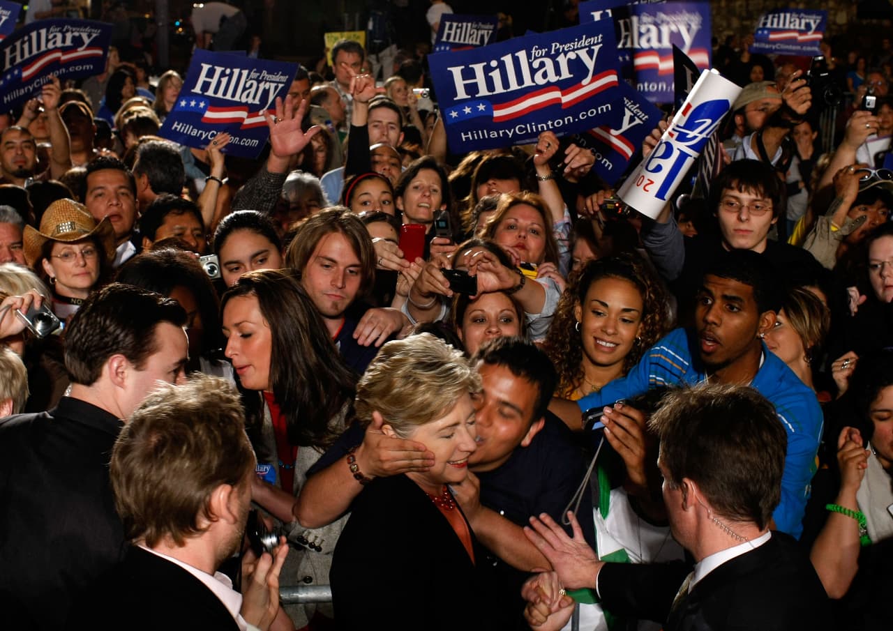 Un partidario agarró la cara de Hillary Clinton y le estampó un beso durante un mitin en la campaña por la nominación demócrata en febrero de 2008, en San Antonio, Texas.