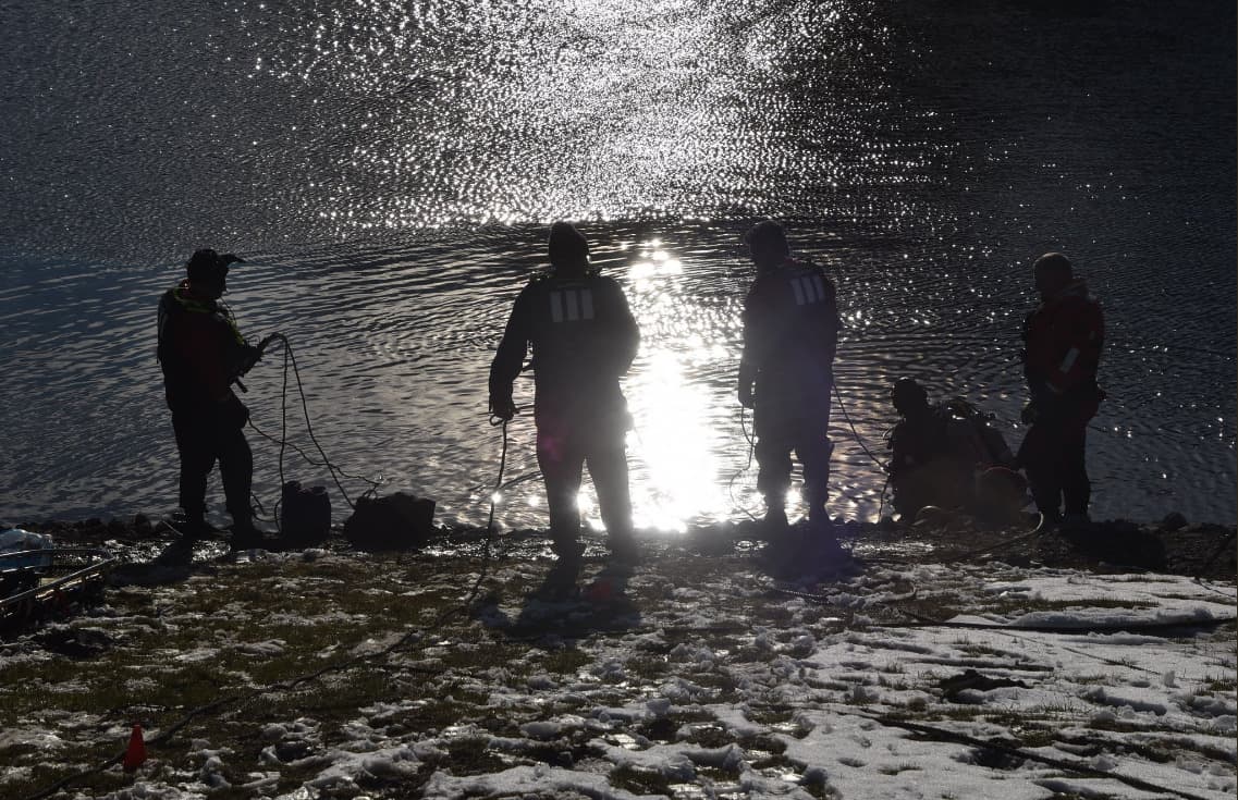 Equipo de buzos de los bomberos cuando intentan rescatar al padre de la niña hundido en el estanque.
