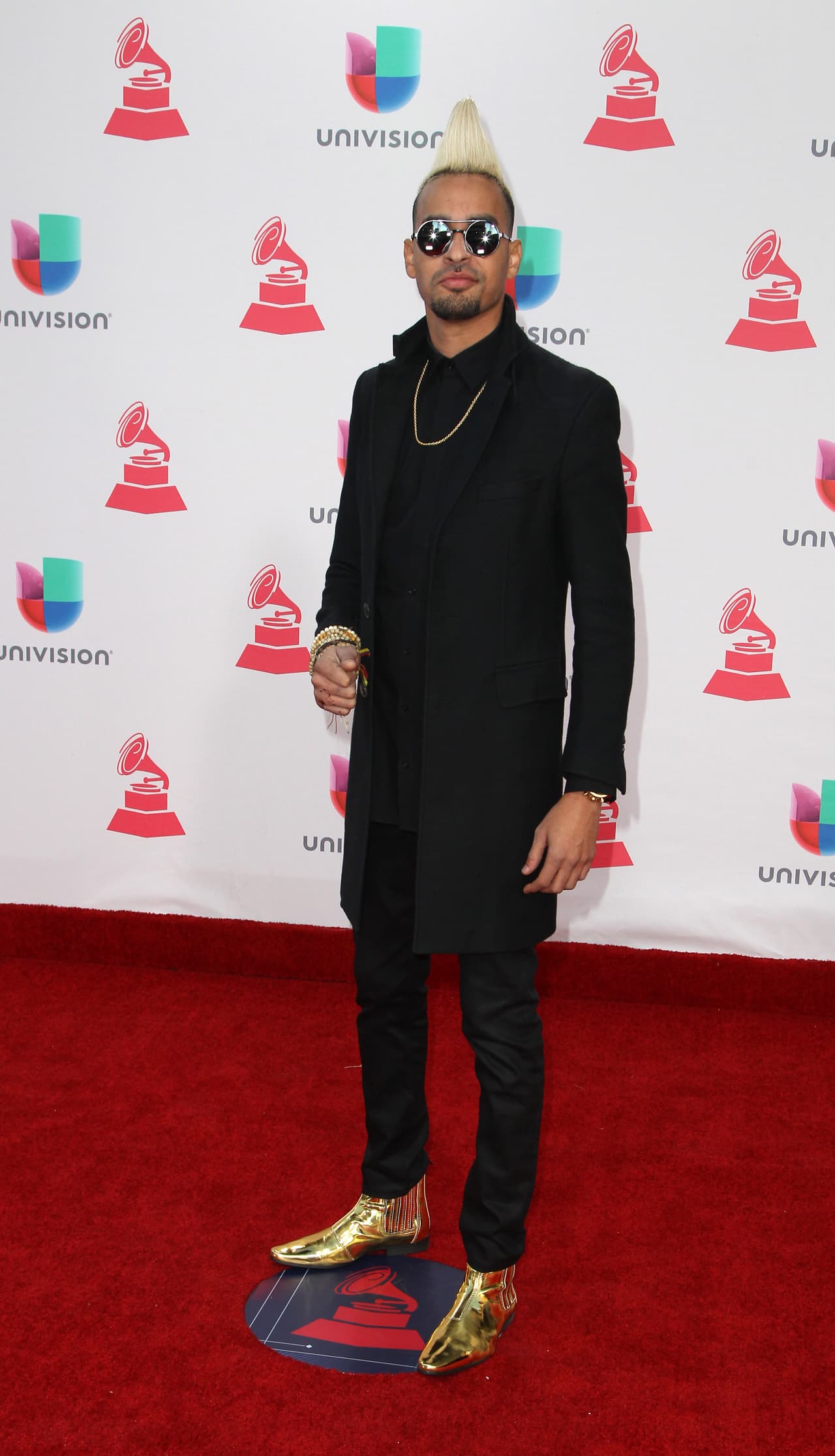 Marcas de diseño como Versace han dejado claro que el color dorado puede ser parte del calzado masculino. En la alfombra el productor Motiff los usó para darle vida a su atuendo completamente negro.