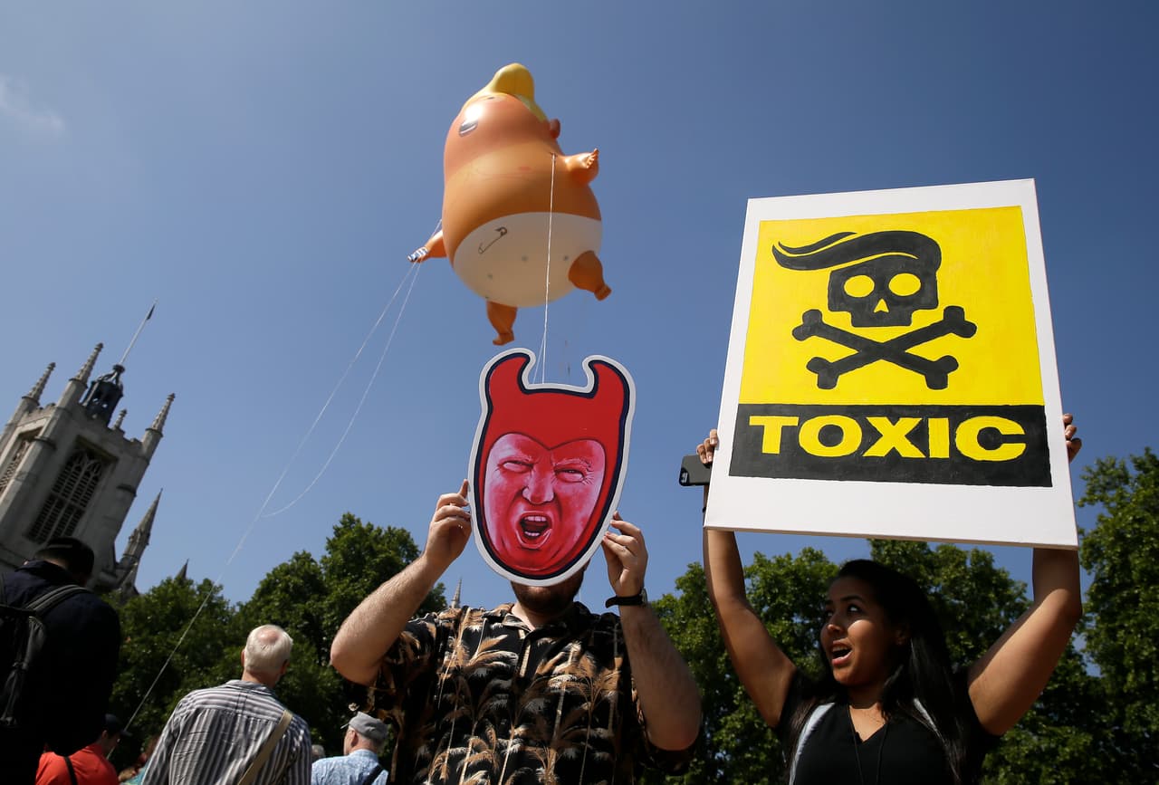 “Tóxico”, dice la pancarta de fondo amarillo. Atrás el 'Bebé Trump' vuela en la plaza del parlamento británico.