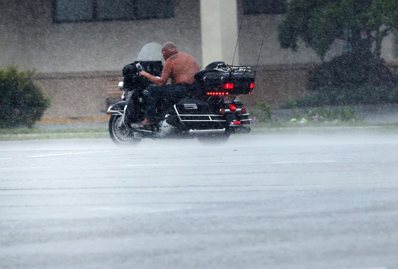 Un hombre monta una motocicleta en medio de vientos huracanados y lluvia provocados por Irma en Bonita Springs, en la costa oeste de Florida. Se espera que sea la costa más afectada por el huracán. 
<br>