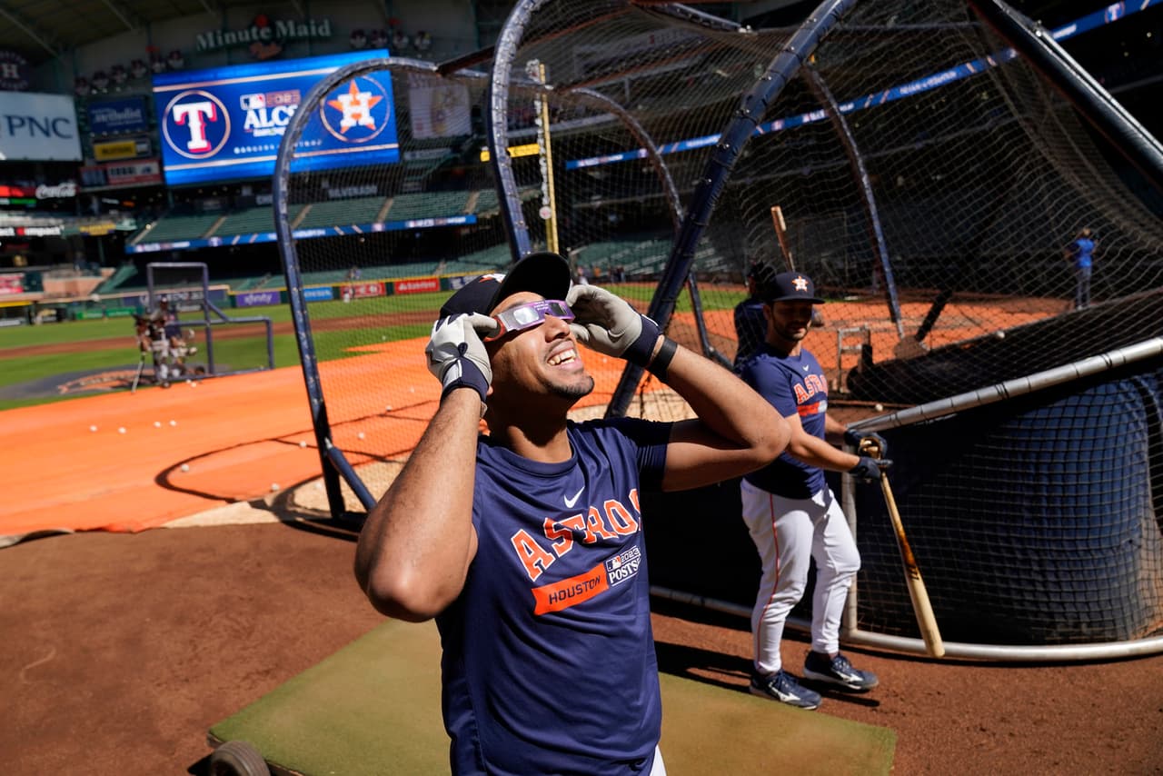Dixon Machado de los Astros de Houston usando sus lentes especiales para ver el eclipse durante la práctica del partido.