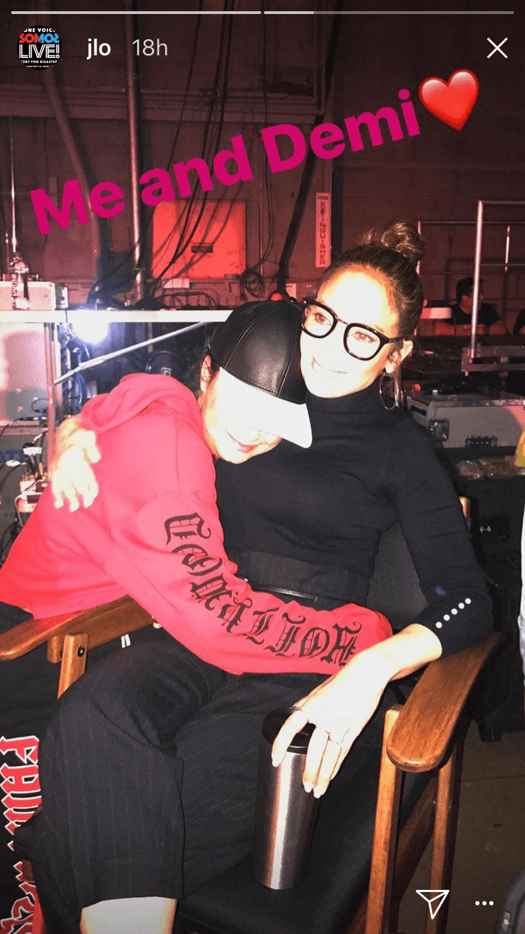 Por la mañana, JLo observaba los ensayos desde su silla de productora con un pescador negro y un top del mismo color, el cabello recogido y unas gafas de mica transparente, aquí en un cariñoso abrazo con Demi Lovato.