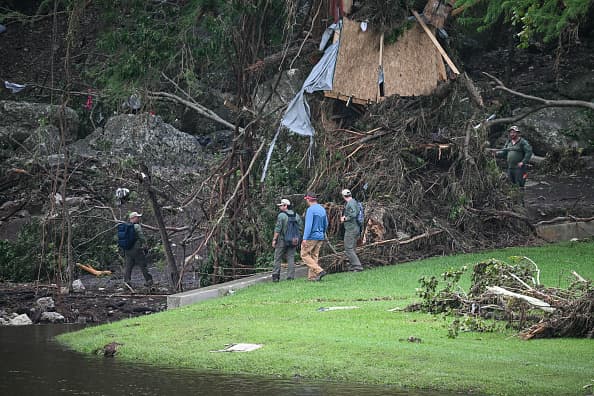 Rescatistas buscan a pie a sobrevivientes. En la imagen se ve la pila de escombros que quedó tras las inundaciones del fin de semana.