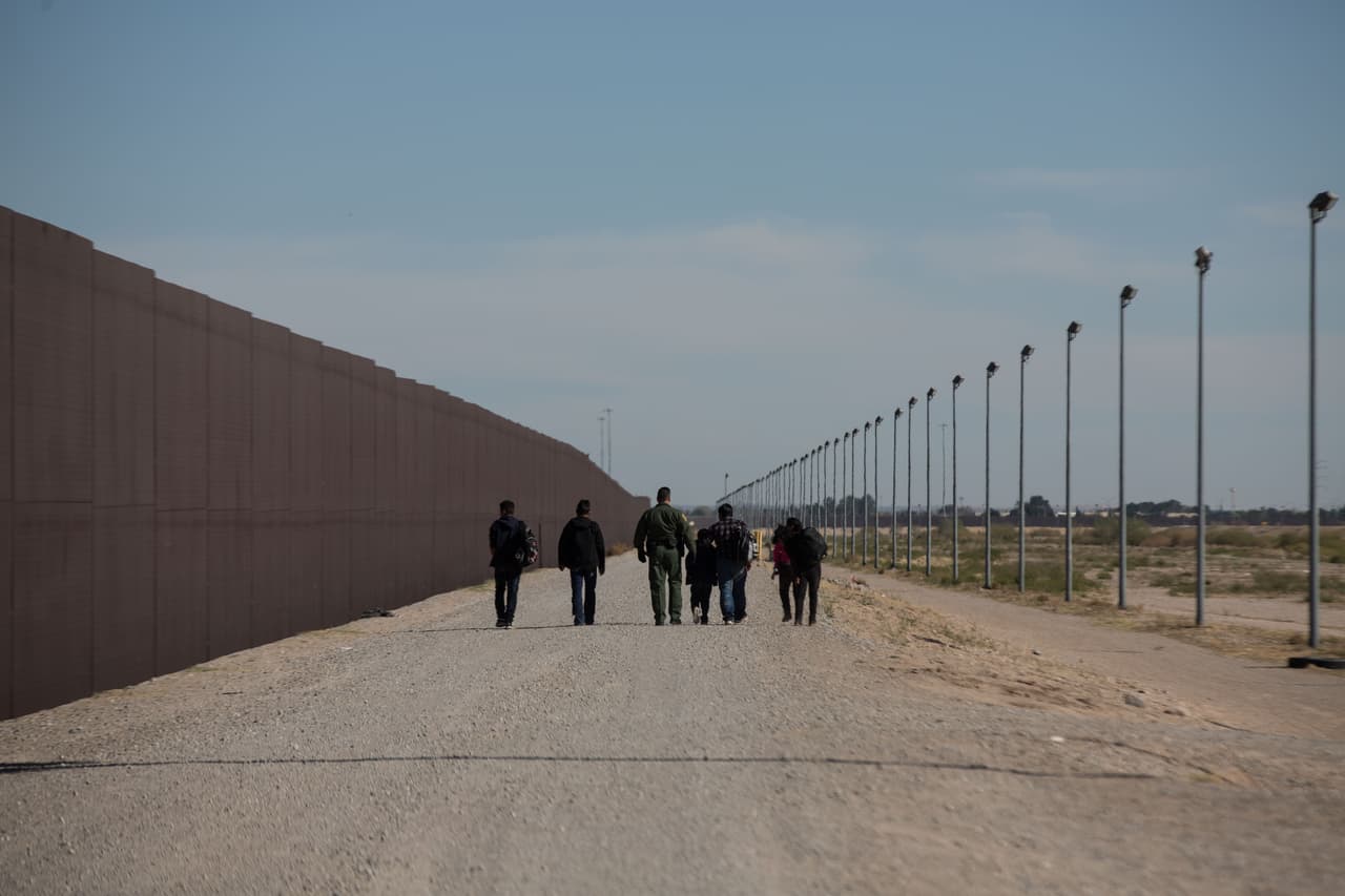 Un agente de la Patrulla Fronteriza acompaña a un grupo de inmigrantes indocumentados hasta una de las puertas de acceso a Estados Unidos, donde los espera otro equipo para trasladarlos al centro donde le hacen las primeras entrevistas para luego remitirlos a ICE.
