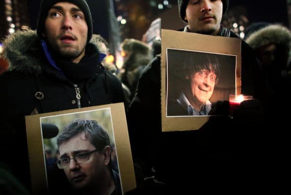 Manifestantes de Union Square sostienen retratos de dos famosos caricaturistas del Charlie Hebdo asesinados el miércoles por terroristas.