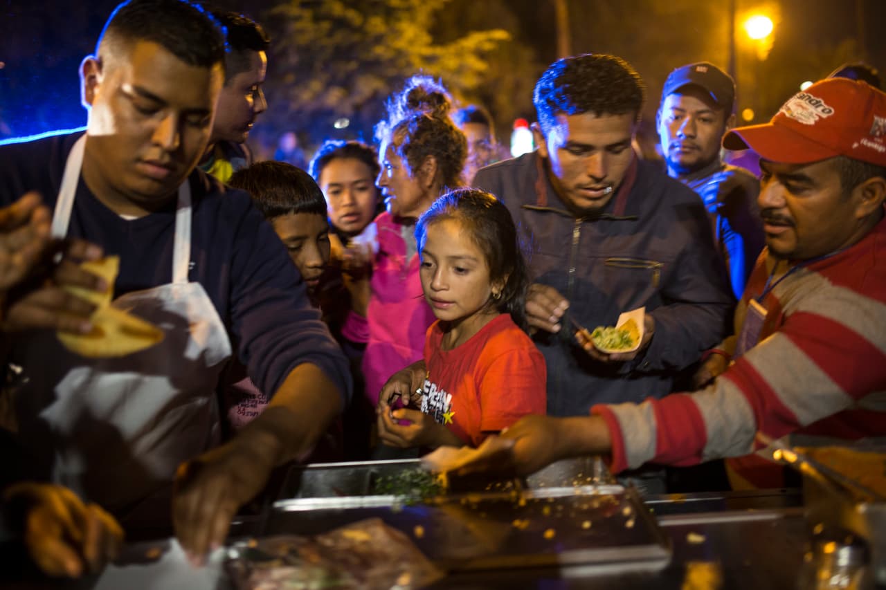 <b>La vida cotidiana en los refugios. </b>Niños y adultos hacen fila cada día para recibir comida o darse un baño en los refugios. En la fotografía decenas de centroamericanos hacen fila para comer en Mexicali. Algunos de ellos continuarán hacia Tijuana.