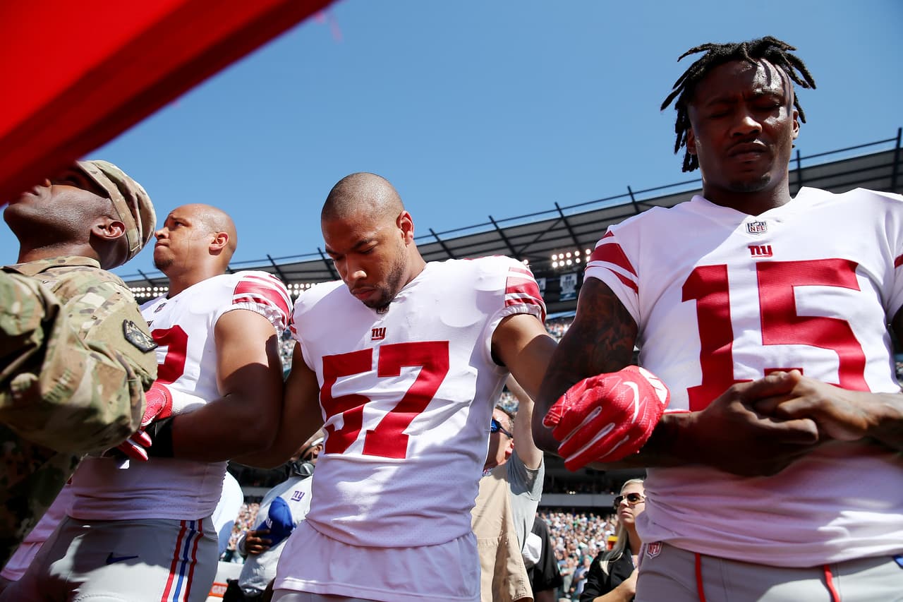 Keenan Robinson (57) y Brandon Marshall (15) de los New York Giants se sumaron a la protesta al comienzo del juego contra los Philadelphia Eagles, en Filadelfia.