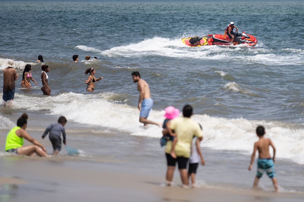 Los salvavidas montan una moto de agua durante una patrulla de tiburones en el Parque Estatal Jones Beach, en Wantagh, Nueva York.