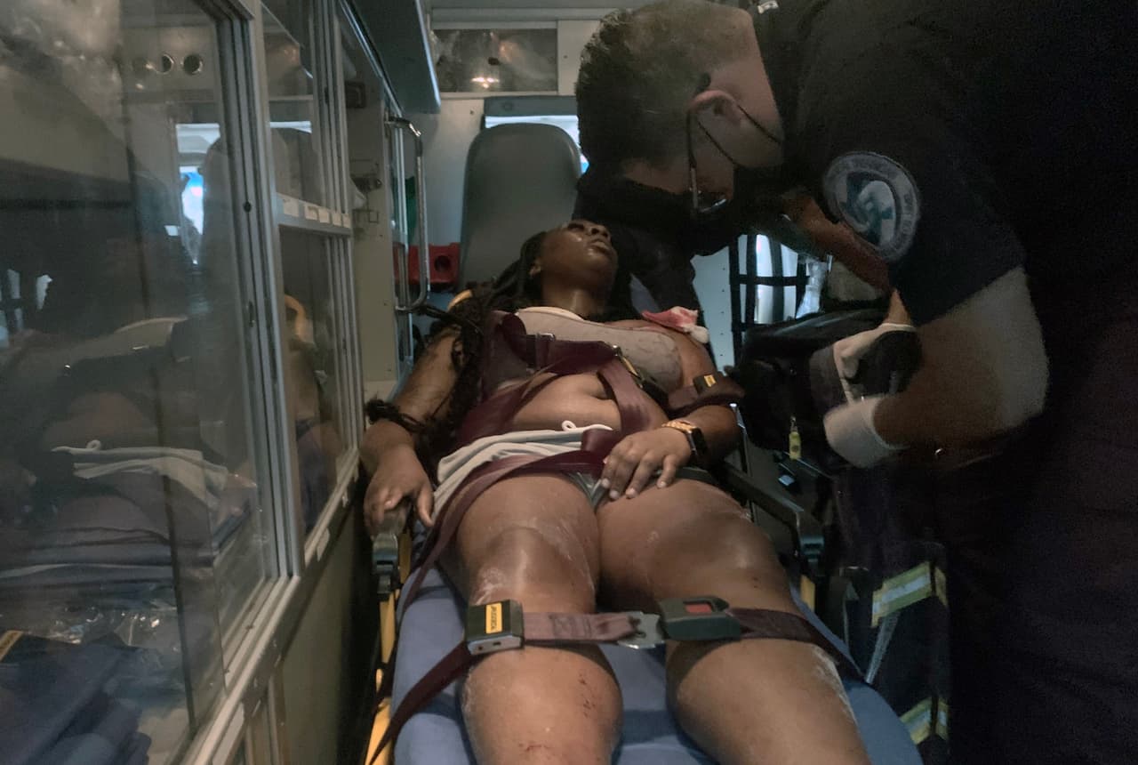 Un paramédico atiende a una turista que resultó herida en un tiroteo en Playa Tortugas, en Cancún, el 11 de junio de 2021.