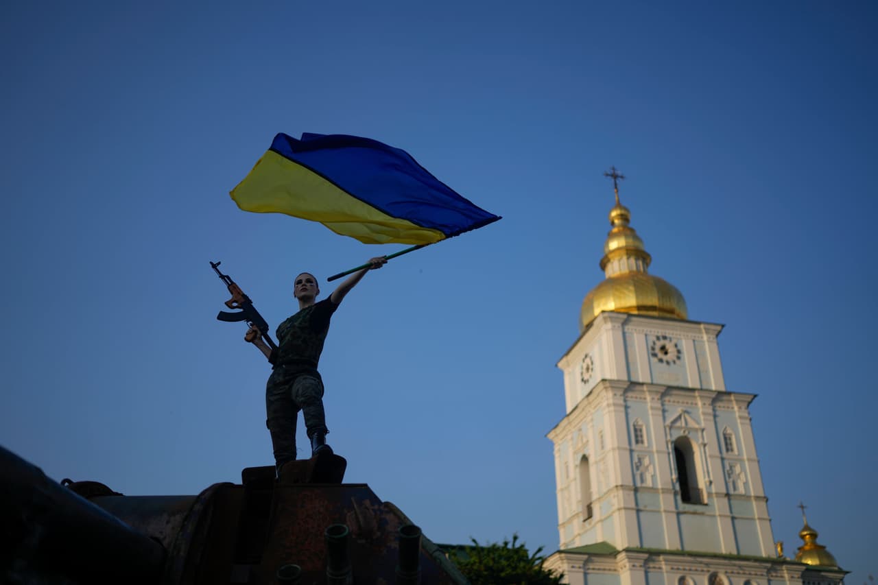 Una mujer blande la bandera ucraniana sobre un tanque ruso destruido en Kiev, el viernes 10 de junio.