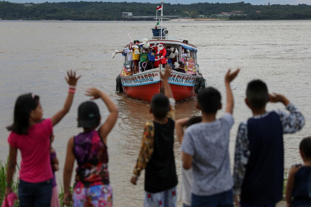 En el corazón de la Amazonía brasileña, Papá Noel se desplaza en una gran lancha a motor, saludando a los niños que lo esperan con ansias en cada orilla.