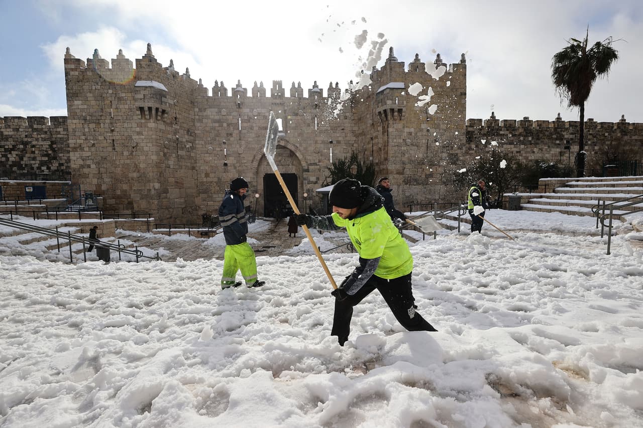Trabajadores de la ciudad limpian la nieve frente a la puerta de Damasco.