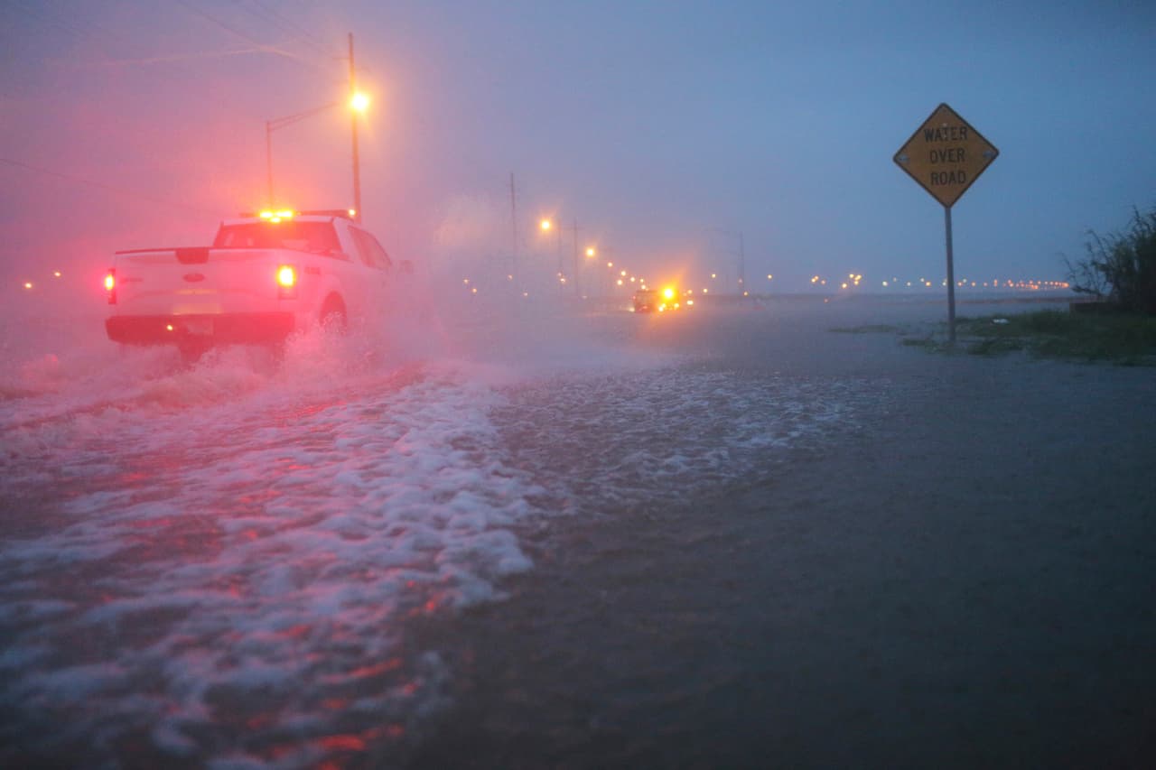 Vehículos del departamento de transporte de Alabama bloquean una parte inundada de la autopista 98 en Spanish Fort.