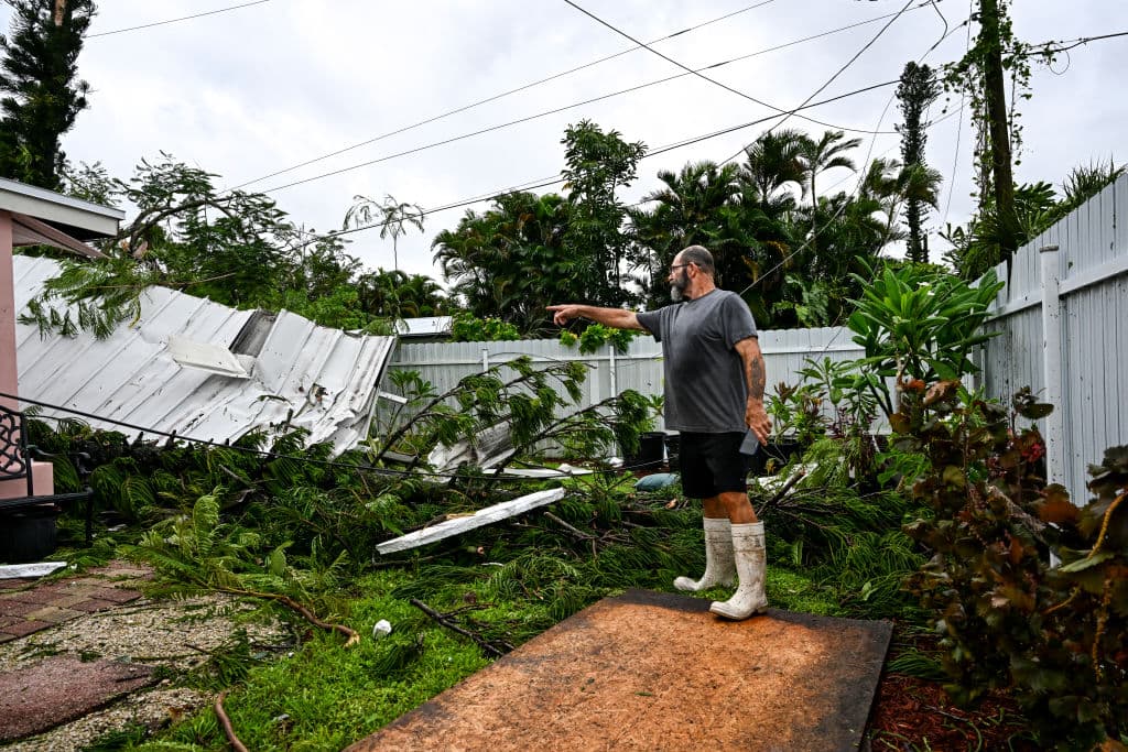 Dan Jones señala un tejado destruido en el patio trasero de su casa tras el paso de un tornado en Fort Myers, Florida.
