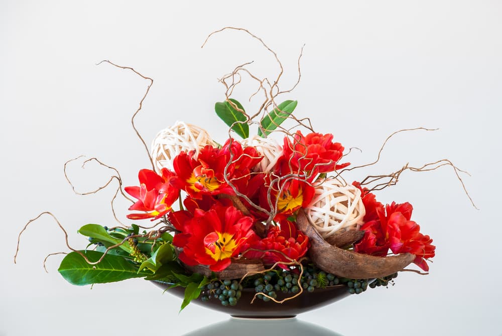 Utiliza flores rojas que corresponden al color básico de tu elemento, fuego, en una disposición triangular, sencilla, pero elegante y refinada combinada con otros elementos que inviten a la meditación e induzcan la paz mental, recuerda que mientras más ordenada y menos cargada de objetos inútiles esté tu casa, mejor fluirá la energía dentro de ella.