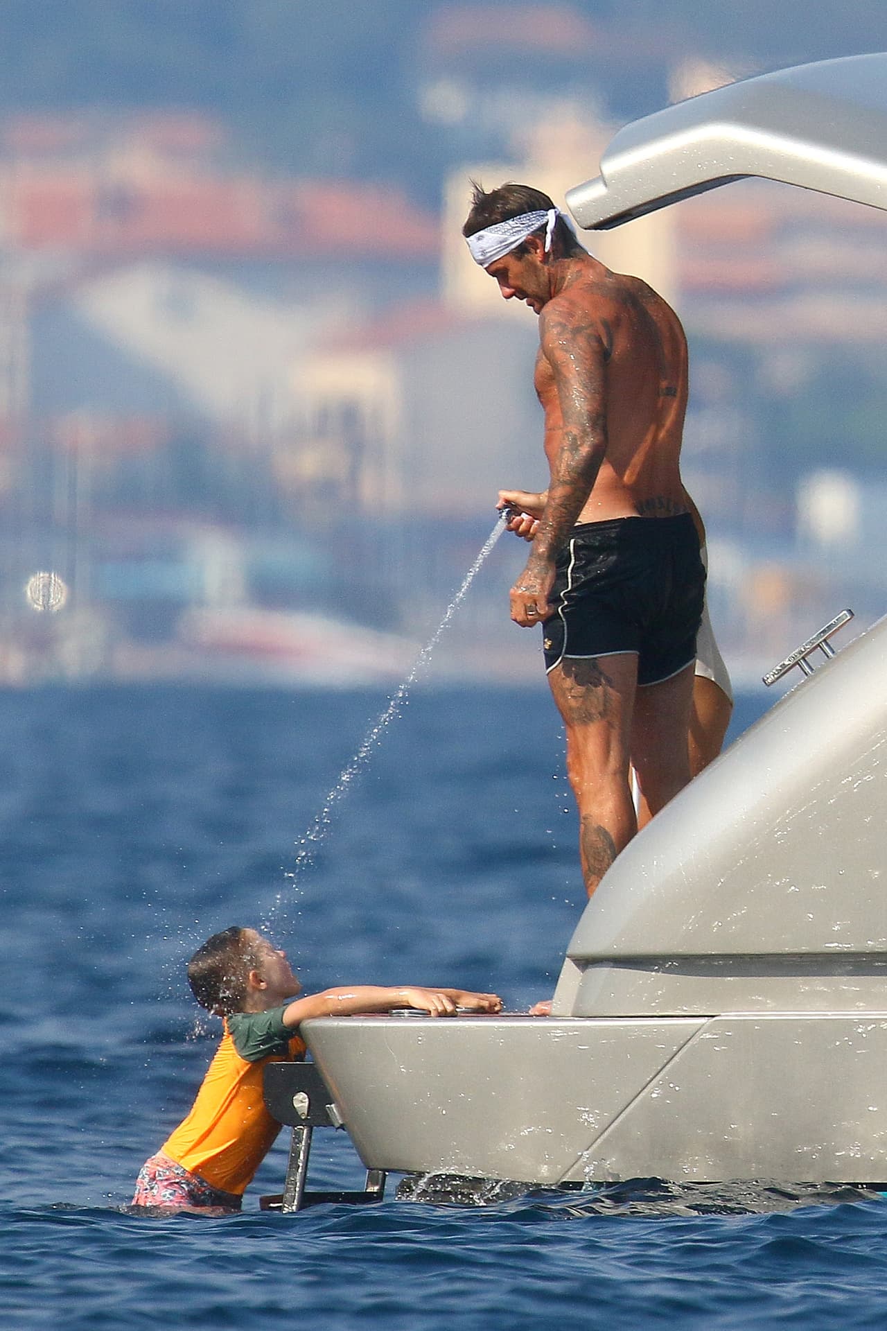 Antes de subir al yate de nuevo, David Beckham bañó con agua de la manguera al mayor de los hijos de Elton John.