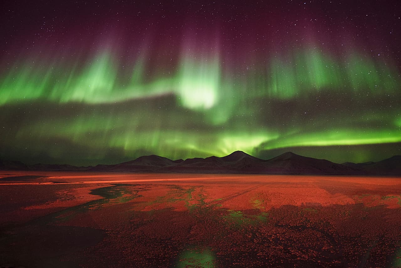 Aurora sobre Svea. Un cielo entre púrpura y verde sobre el pueblo minero de Svea en el archipiélago de Svalbard en Noruega.