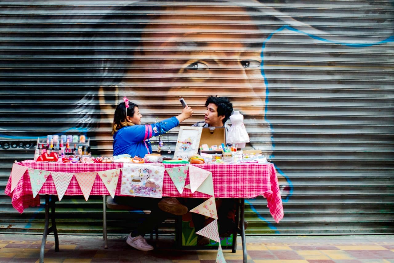 "Pegados al muro, jóvenes tomando una "selfie" en un mercado en Tijuana, Baja California".